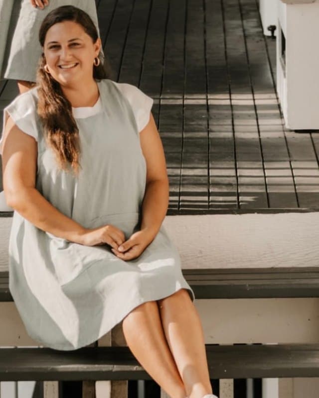 Katelyn, founder of The Windermere Agency, seated on a porch step in warm natural light